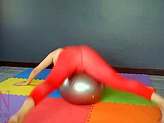 Regina Noir, uma mulher madura, pratica yoga na academia enquanto usa um collant vermelho, meia-calça de ioga e é depilada