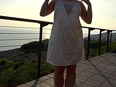Mature woman in white dress has outdoor sex on balcony