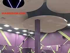 Mujer enmascarada hace ejercicio en solitario en el gimnasio