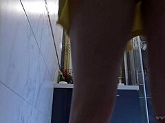 אישה קטנה עם חזה גדול מתכופפת כדי להחליף תחתונים בחדר האמבטיה