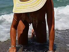 Moden kvinde med strakte piercinger i brystvorten og flere fissepiercinger på stranden
