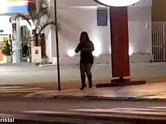 المرأة الناضجة تتباهى بمنحنياتها في محطة وقود بعد الظلام.