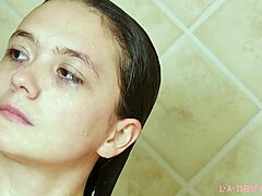 Modelul brunet atrăgător face baie într-un duș fierbinte