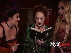 Skupina zrelih žensk se ukvarja s spolnim obredom, oblečena v čarovnice