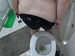 Une femme mûre aux gros seins est filmée dans les toilettes