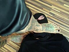 Uma MILF tatuada domina seu escravo de pés em um vídeo quente descalço