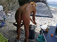 Seorang ibu nakal dengan puting tertusuk dan lubang dubur menikmati kehidupan telanjang di pantai