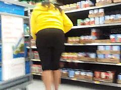 Siyah bir kadın mağazada büyük kalçalarını sergiliyor