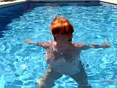 Busty mature redhead Melanie enjoys a swim with Auntjudys in her bikini